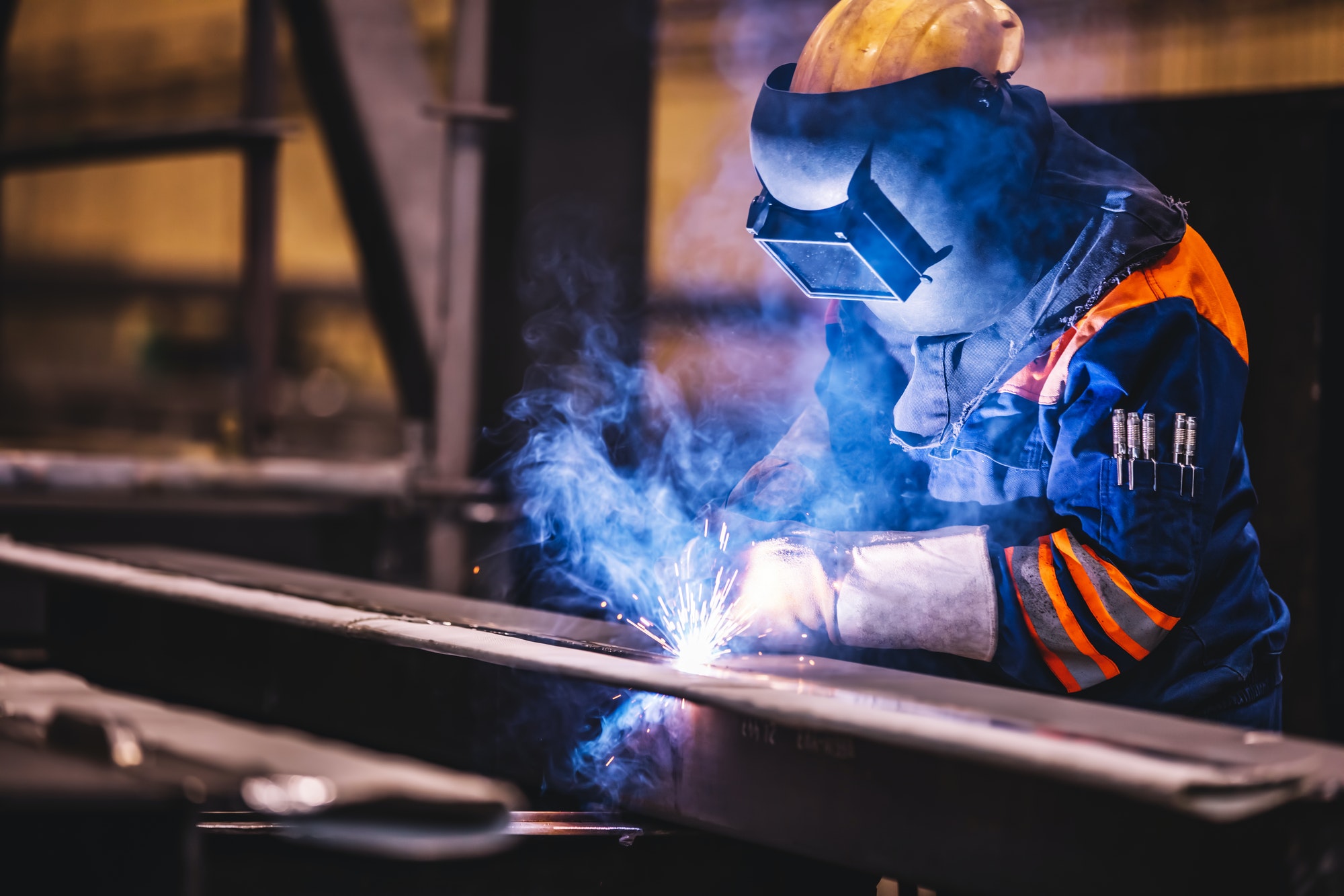 Worker welding in a factory.